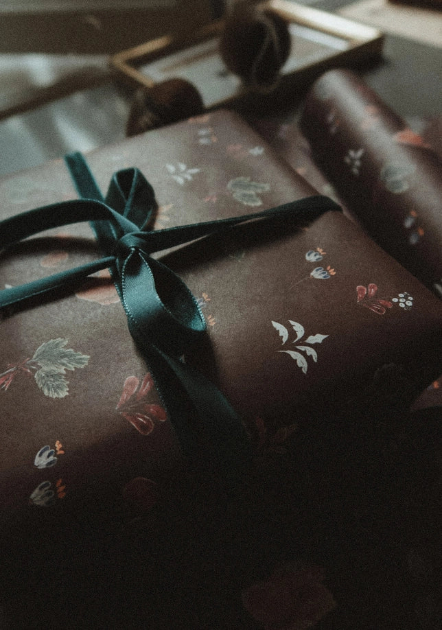 Juego de 3 piezas florales navideñas y marrones sobre papel de regalo blanco