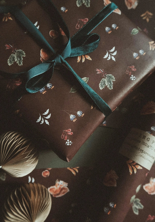Juego de 3 piezas florales navideñas y marrones sobre papel de regalo blanco