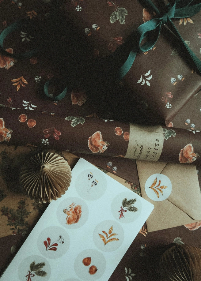 Juego de 3 piezas florales navideñas y marrones sobre papel de regalo blanco
