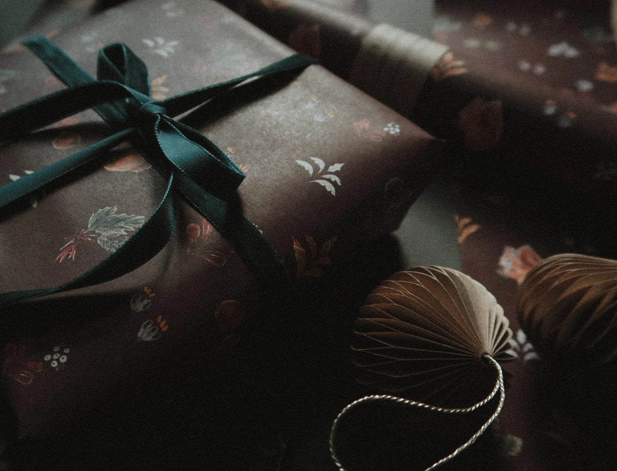 Juego de 3 piezas florales navideñas y marrones sobre papel de regalo blanco